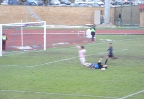 Foto inequivocabile dove si vede l'attaccante cadere a terra e il pallone che si trova lontano dai giocatori